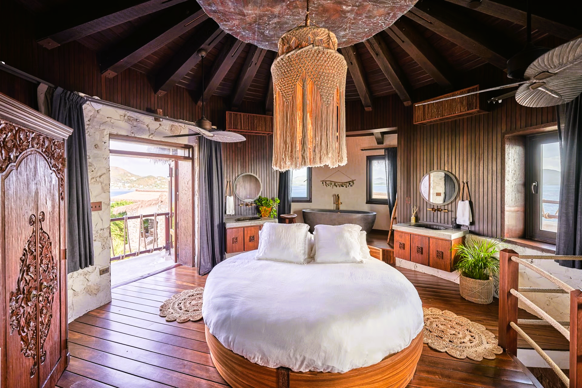 A bedroom with a round bed and a chandelier hanging from the ceiling.