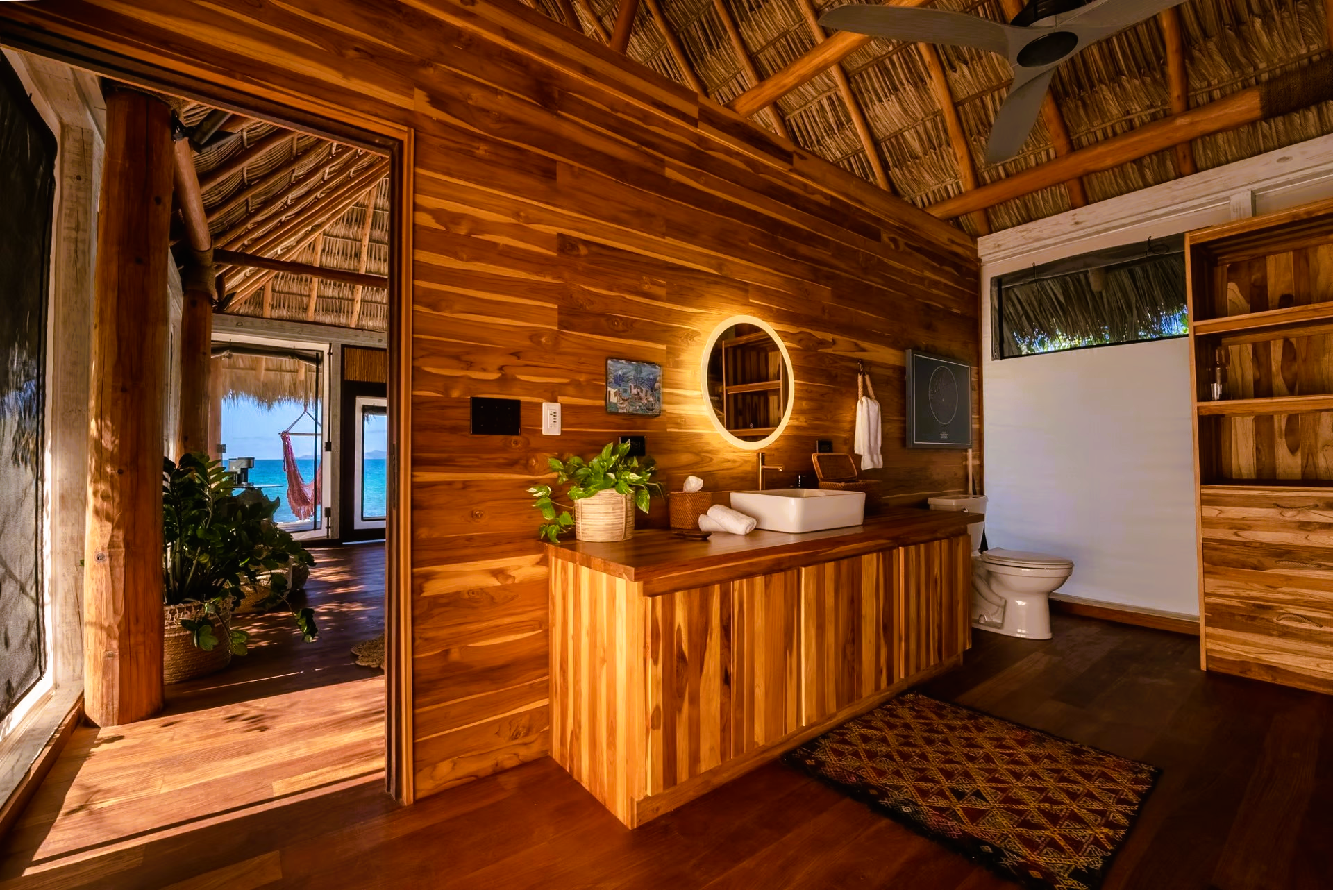 A bathroom with wooden walls , a sink and a toilet.