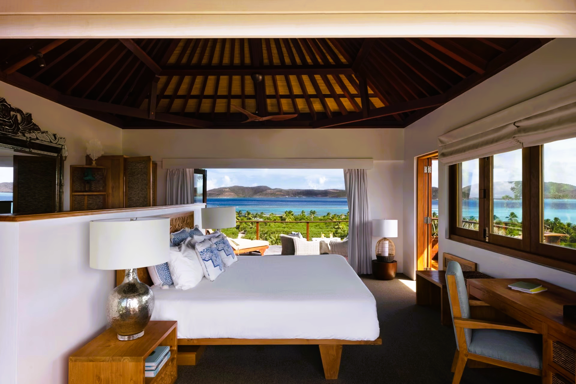 A bedroom with a large bed and a view of the ocean