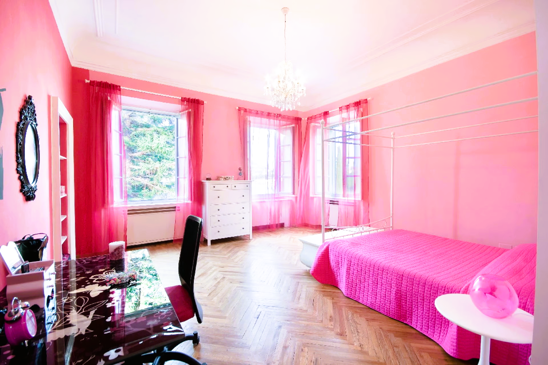 A bedroom with pink walls and a pink bed