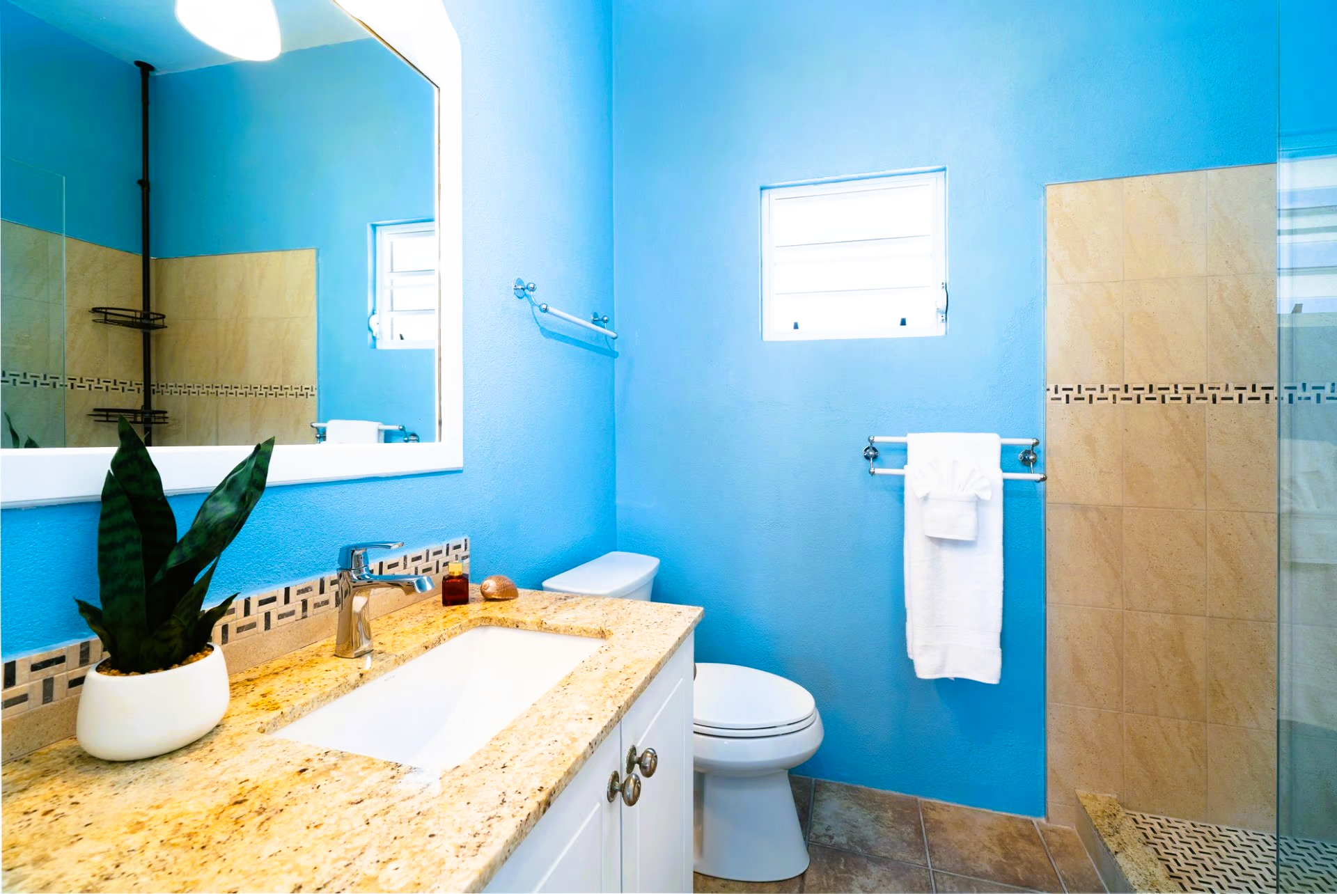 A bathroom with a toilet a sink and a mirror