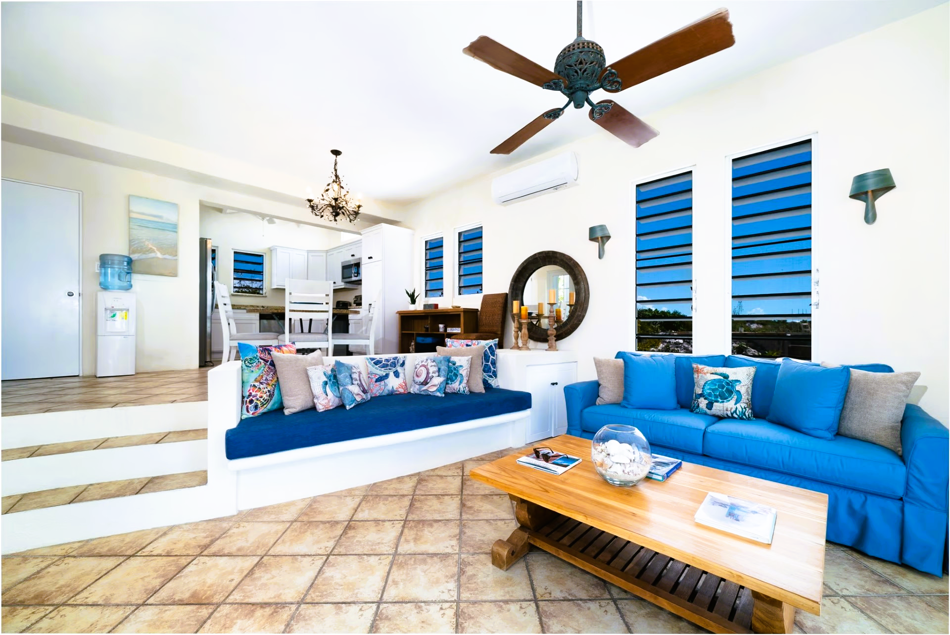 A living room with a blue couch and a ceiling fan.