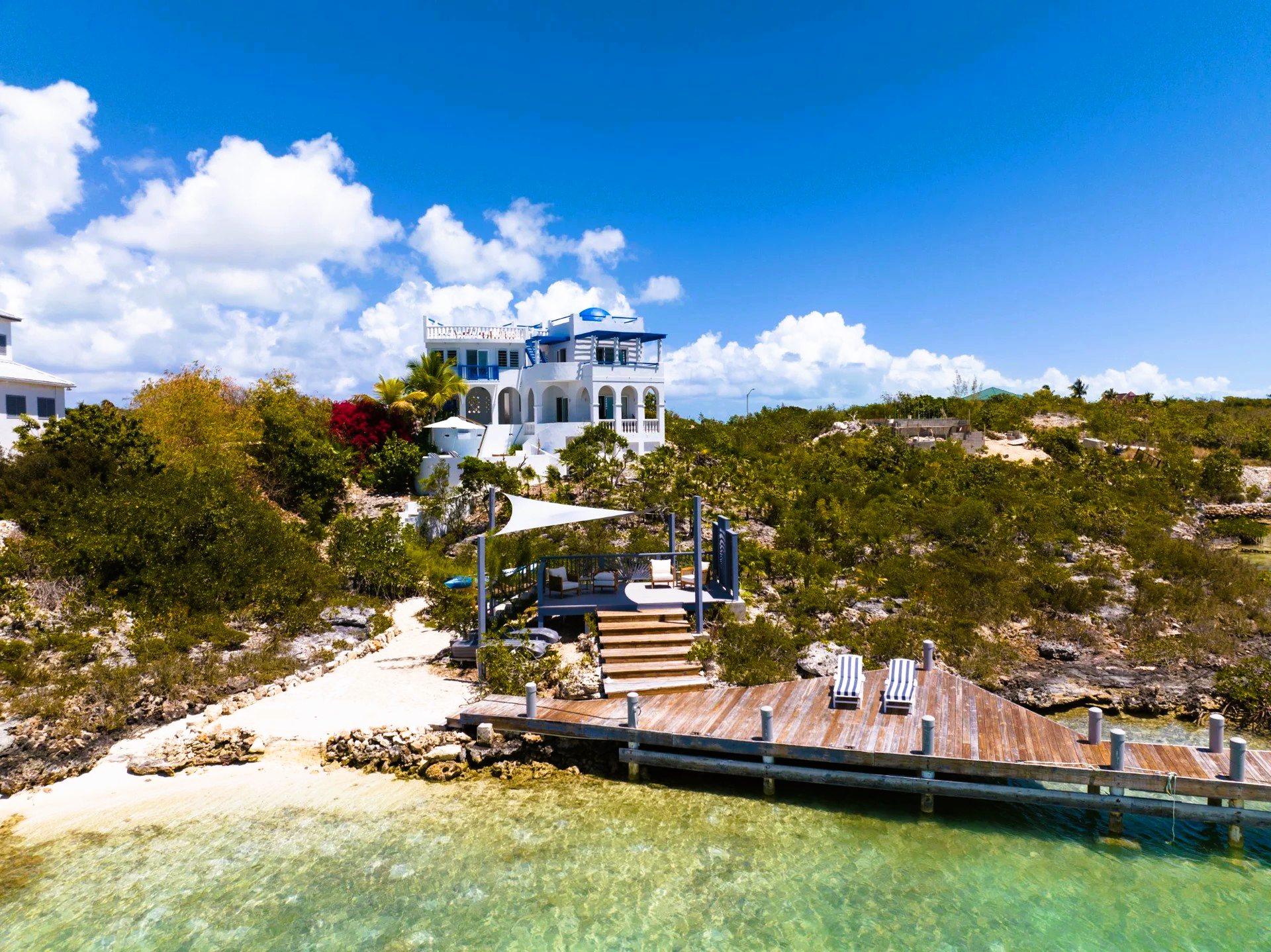 An aerial view of a large white house on a small island