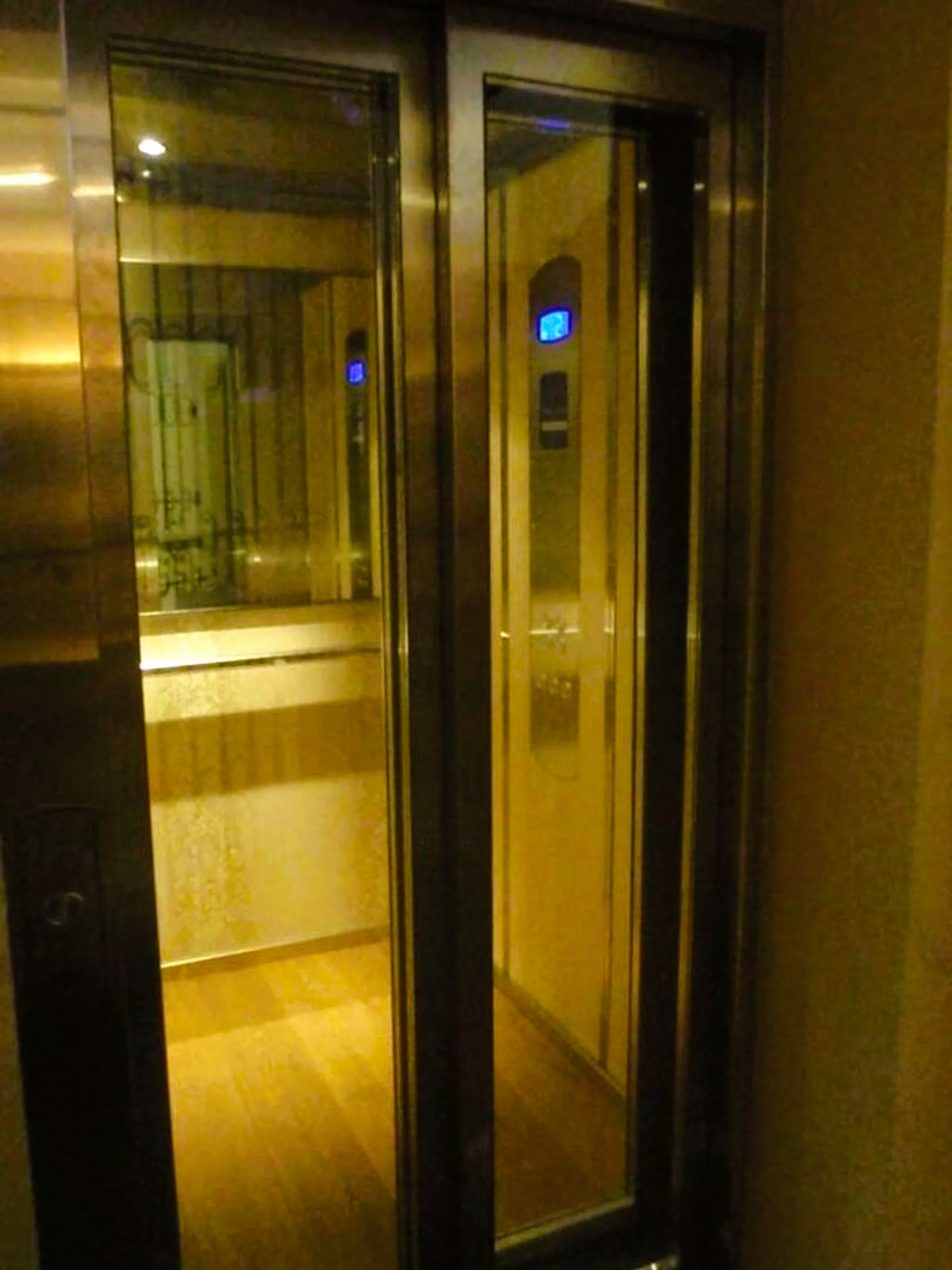 A stainless steel elevator with a glass door