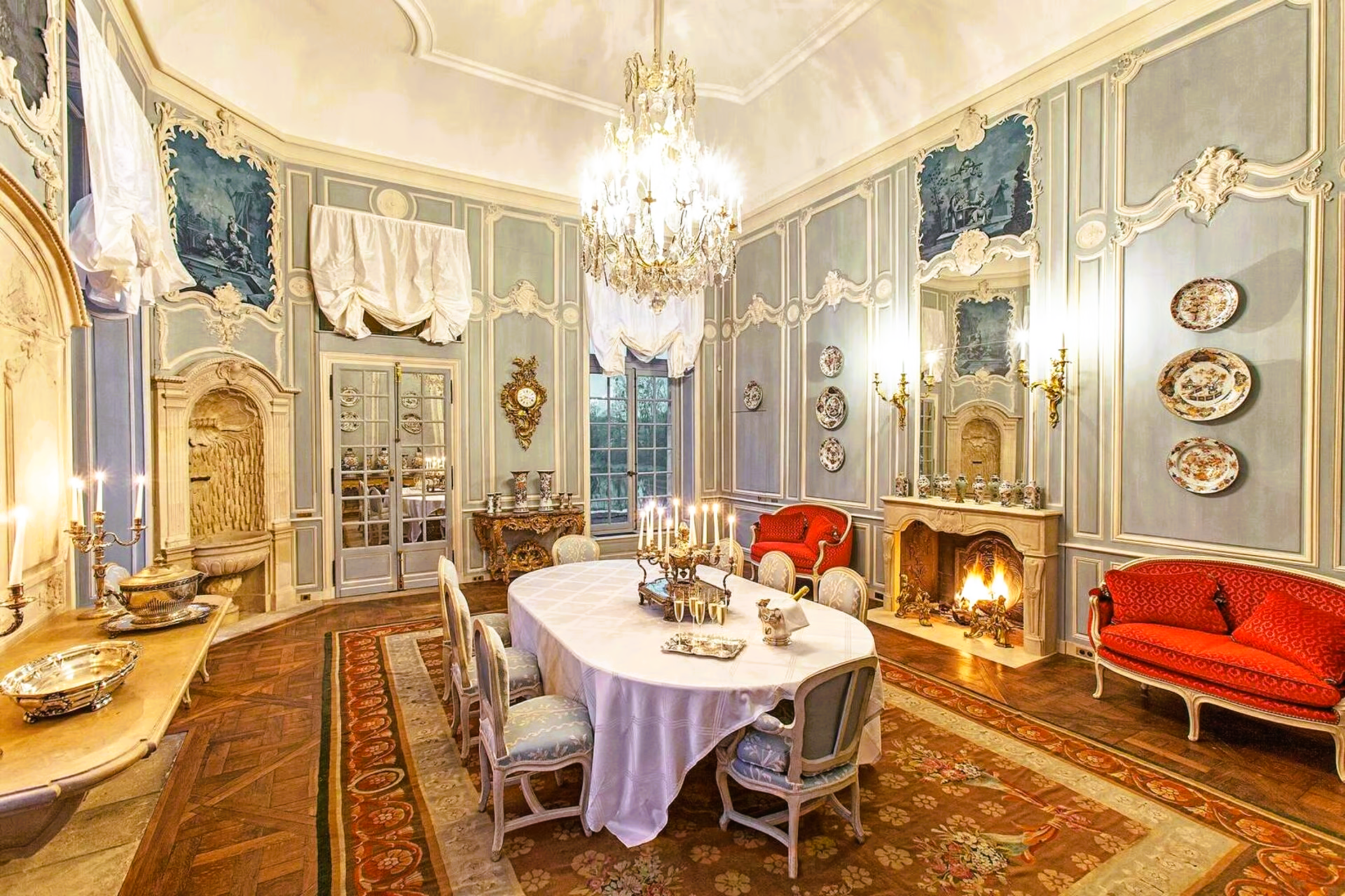 A large dining room with a table and chairs and a fireplace.