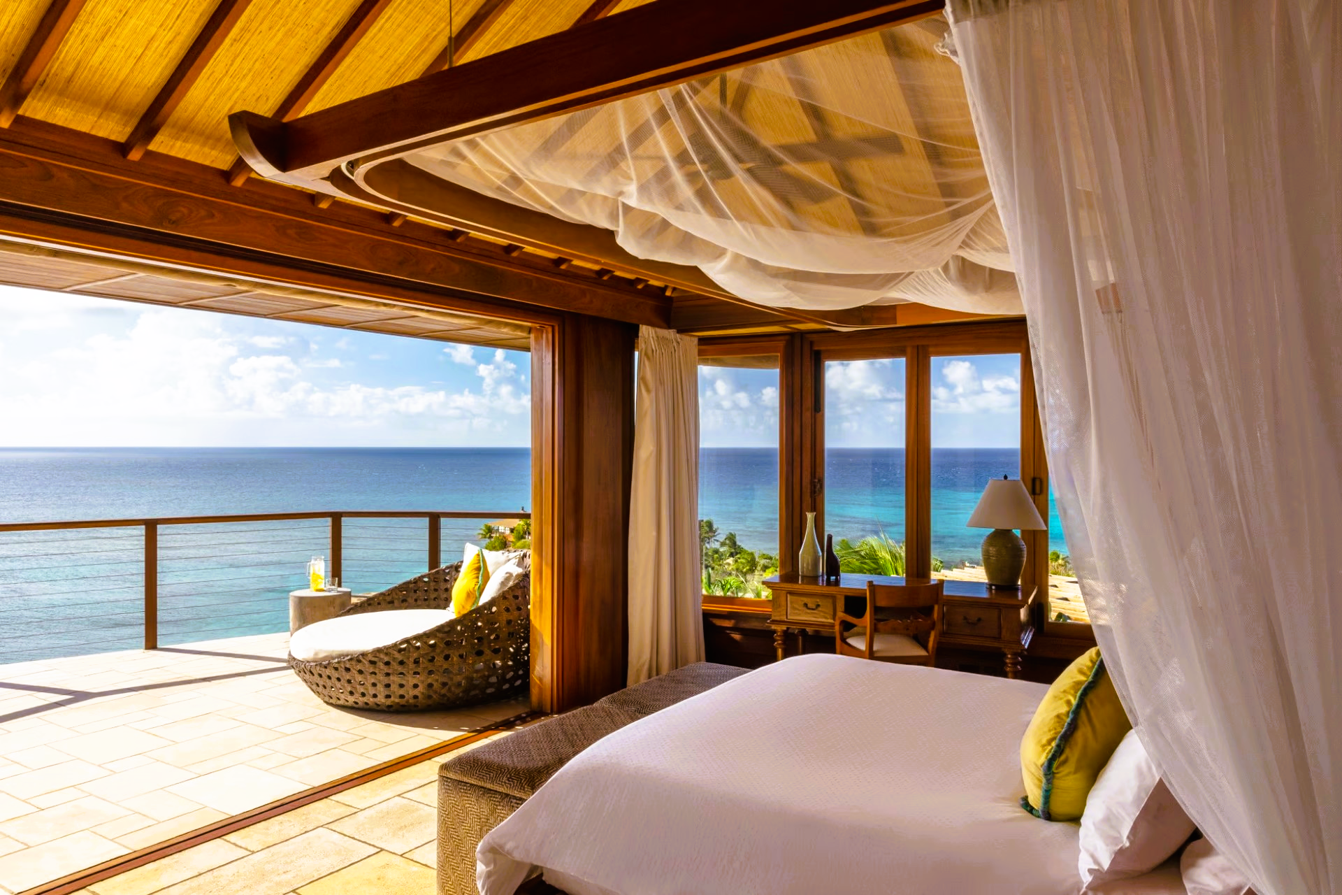 A bedroom with a canopy bed and a view of the ocean