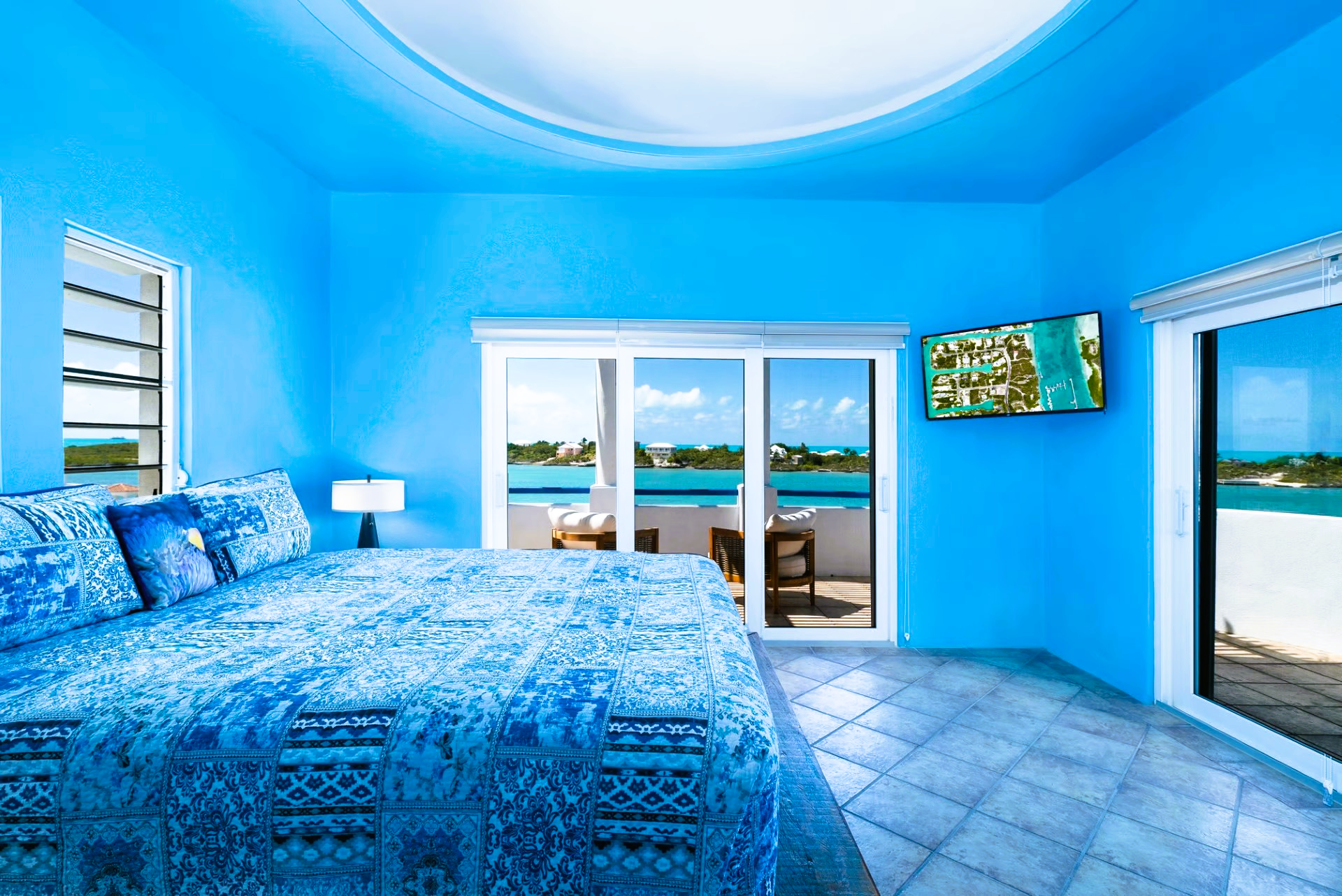 A bedroom with blue walls and a blue bed