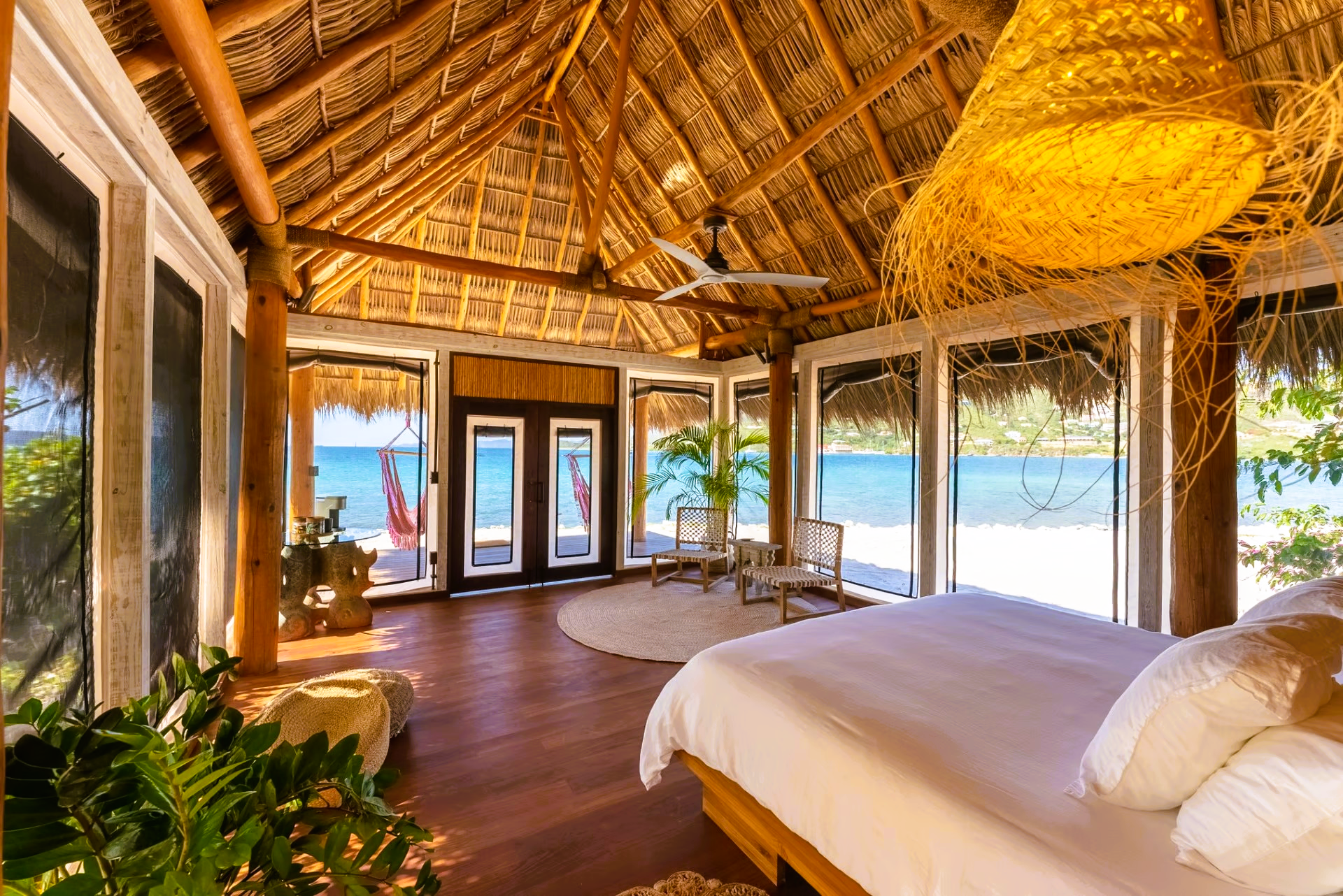 A bedroom with a thatched roof and a large bed