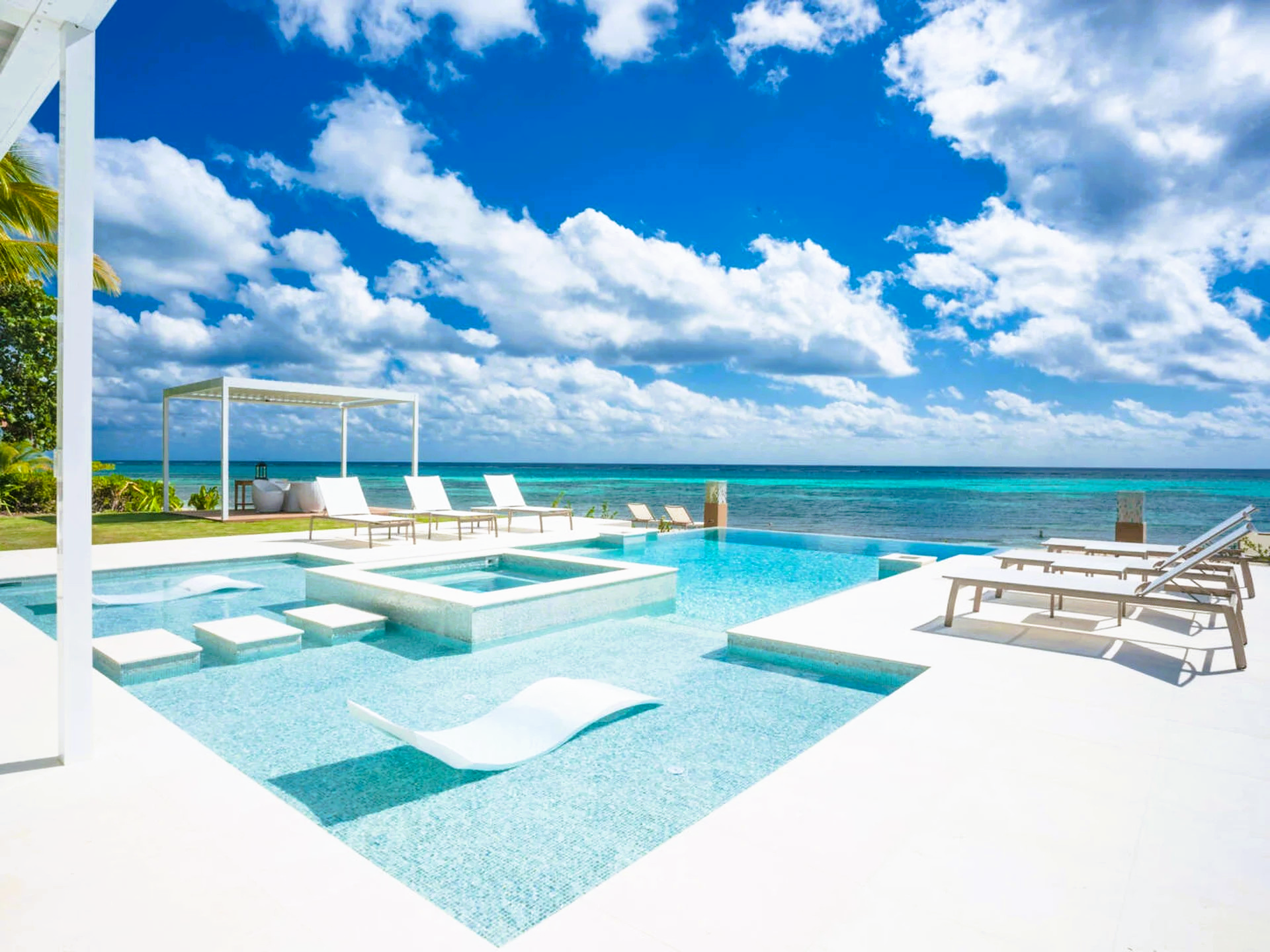 There is a large swimming pool with a view of the ocean.