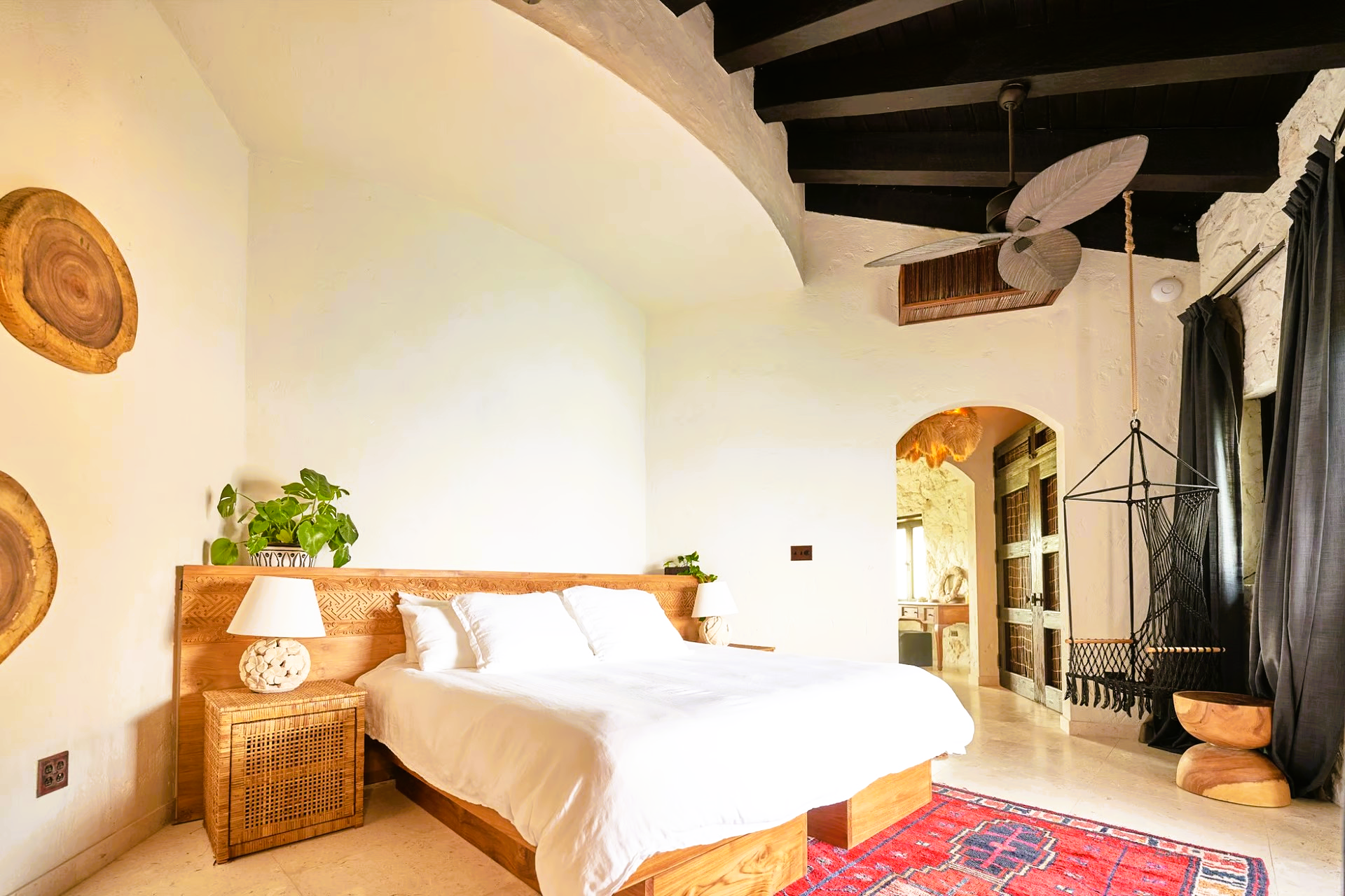 A bedroom with a large bed and a ceiling fan