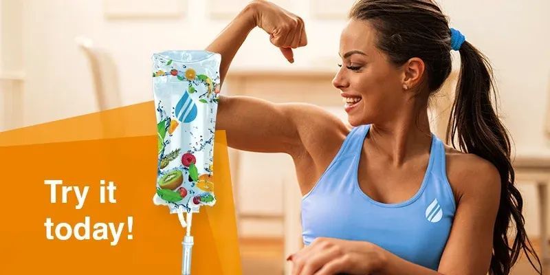 A smiling person in a blue athletic top flexes their arm next to a fruit-patterned IV drip bag with the text 