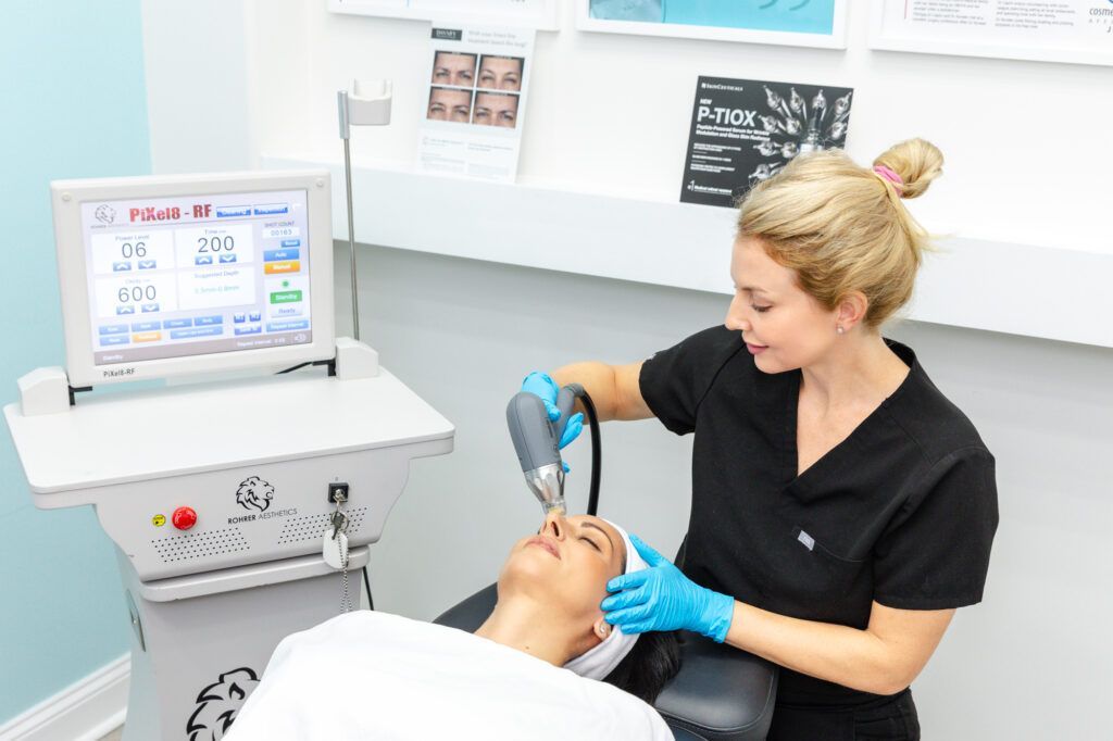 A woman is getting a microneedle treatment on her face.