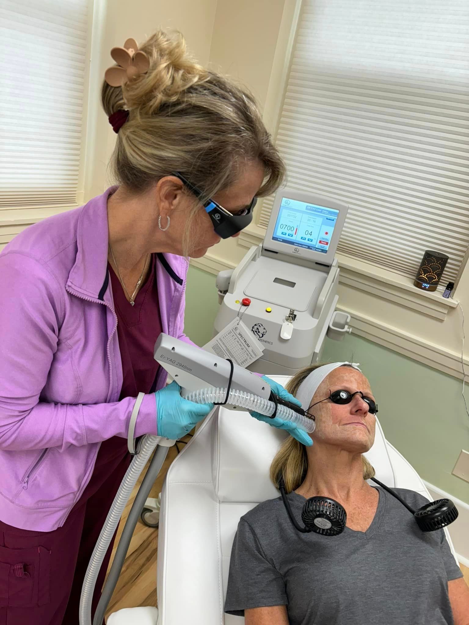 A woman is getting a laser treatment on her face.