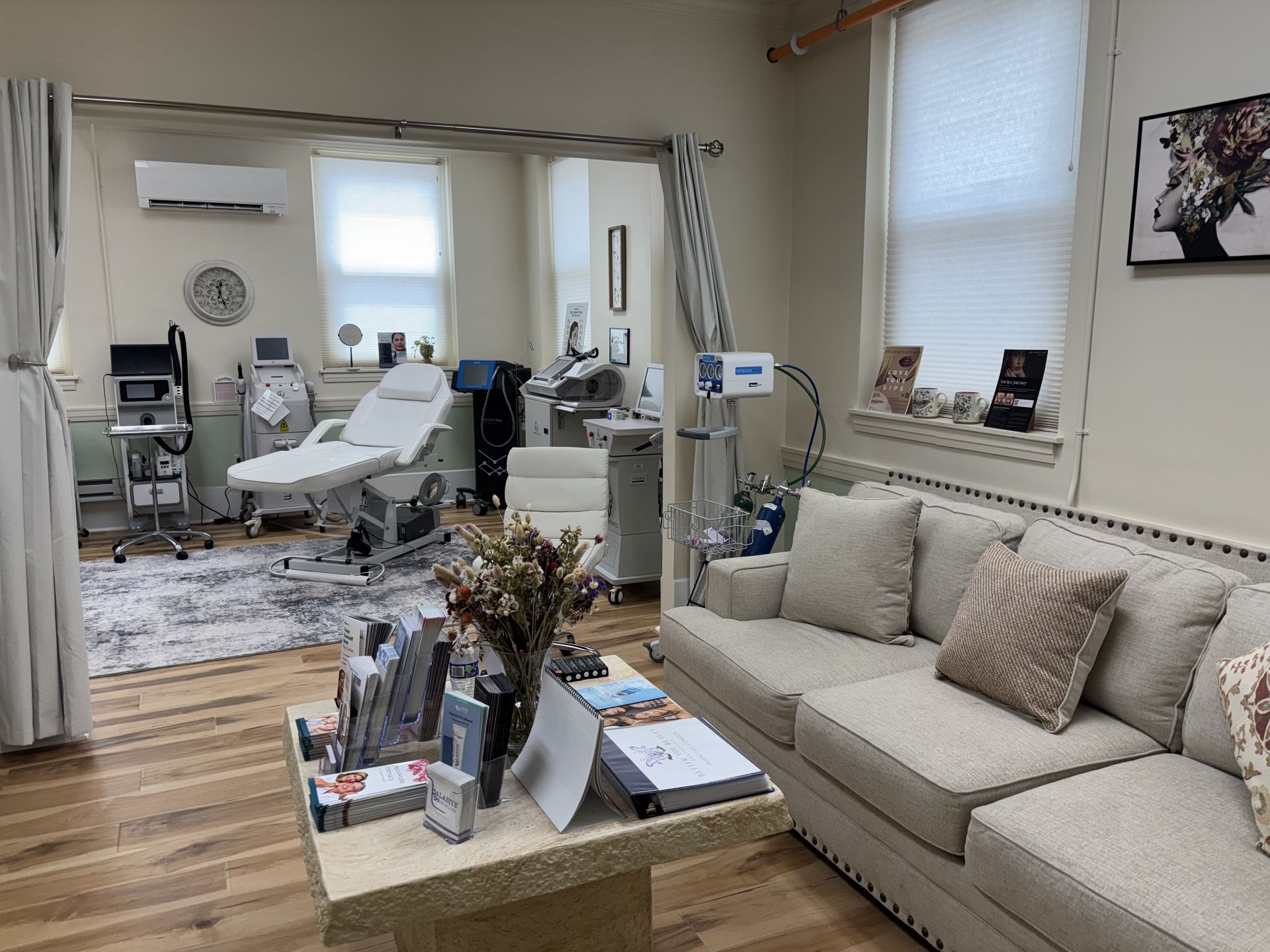 Salon interior with aesthetic equipment, a couch, and a treatment bed.