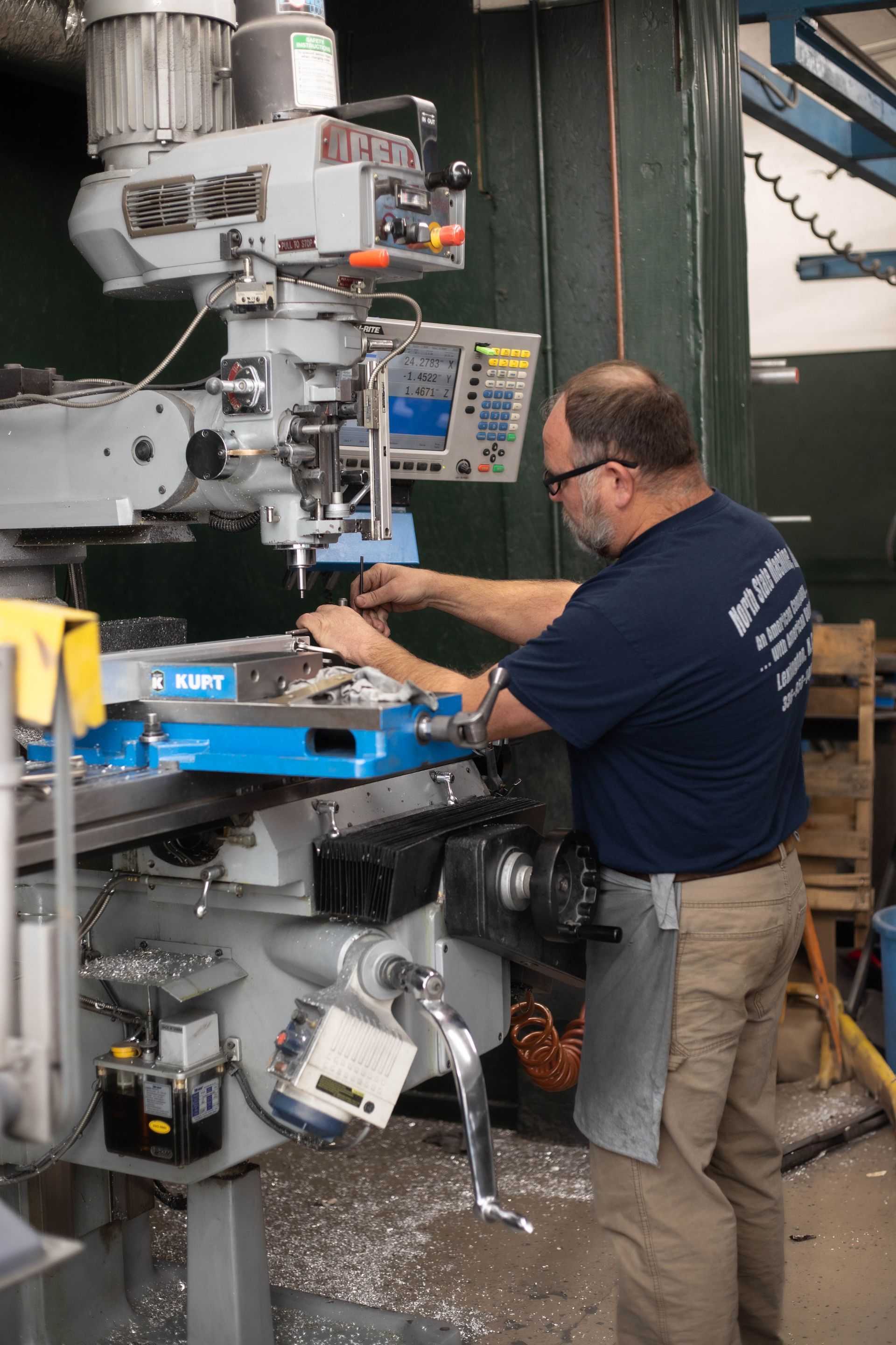 A man in a blue shirt is working on a machine
