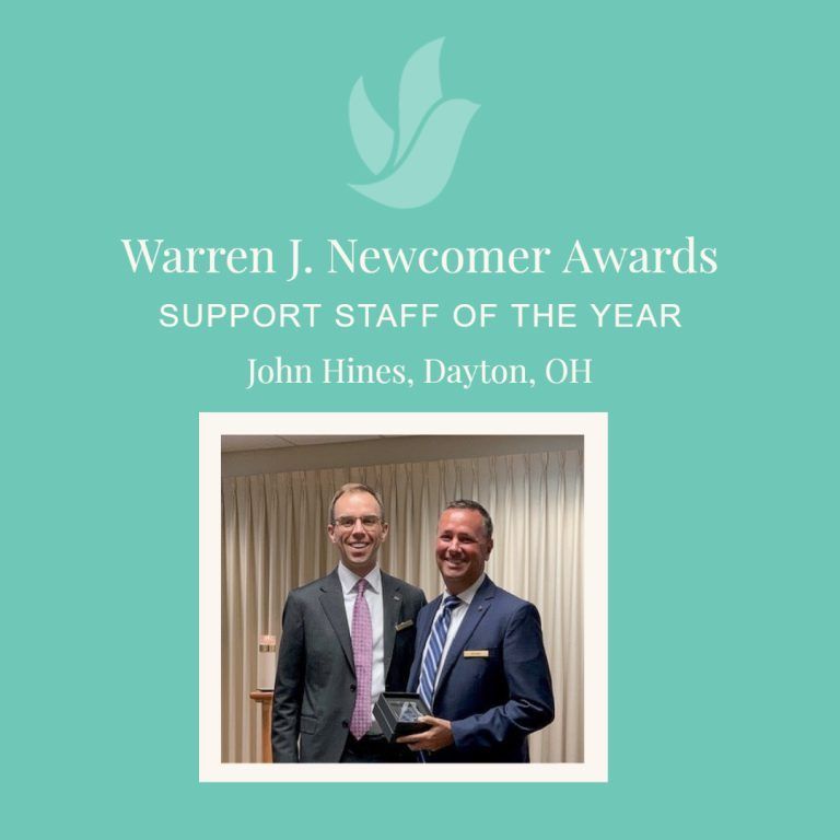 Two men at an award ceremony, one holding a trophy. Text reads