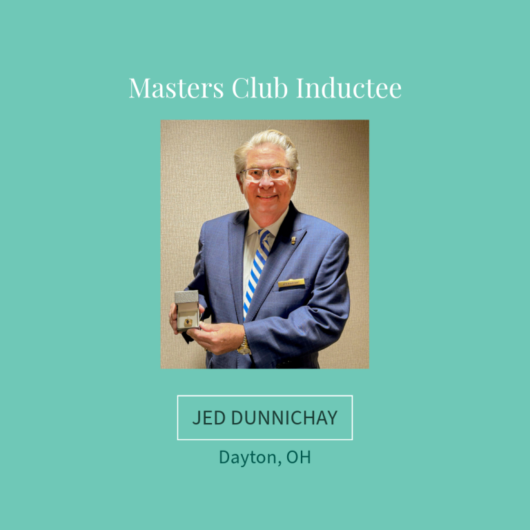 Jed Dunnichay, Masters Club Inductee in Dayton, OH, holding a small award, wearing a blue suit and tie.