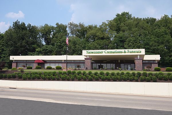 Newcomer Cremations & Funerals building with red awning and green landscaping.