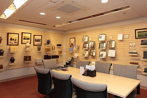A conference room with items displayed on the wall, with a table and chairs.