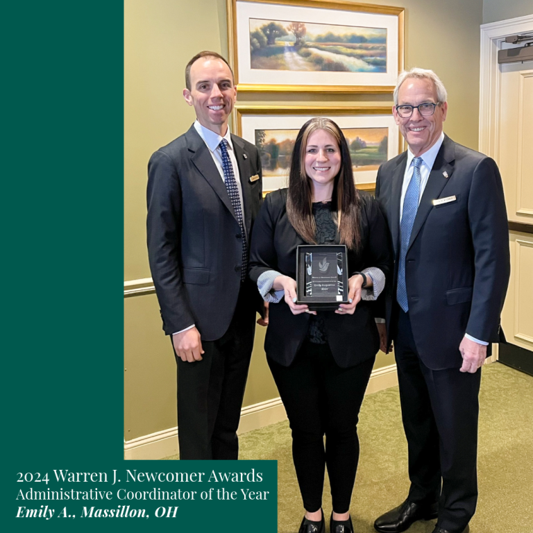 Three people pose for an award. Emily A. of Massillon, OH holds an award plaque, smiling, flanked by two men in suits.