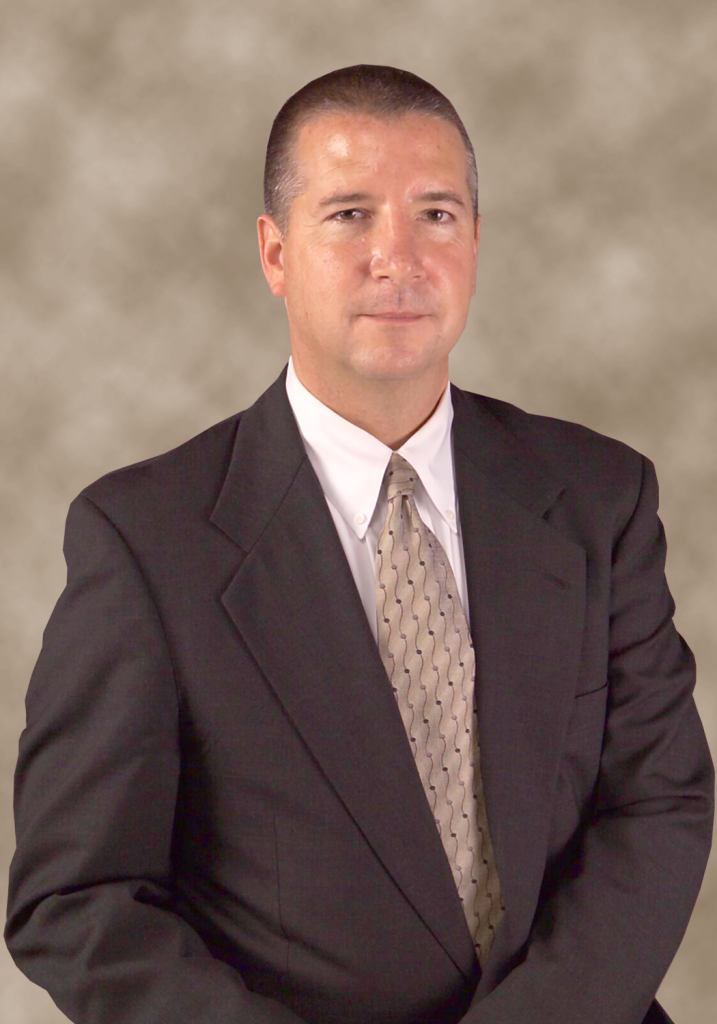 Man in a suit and tie posing for a professional headshot.
