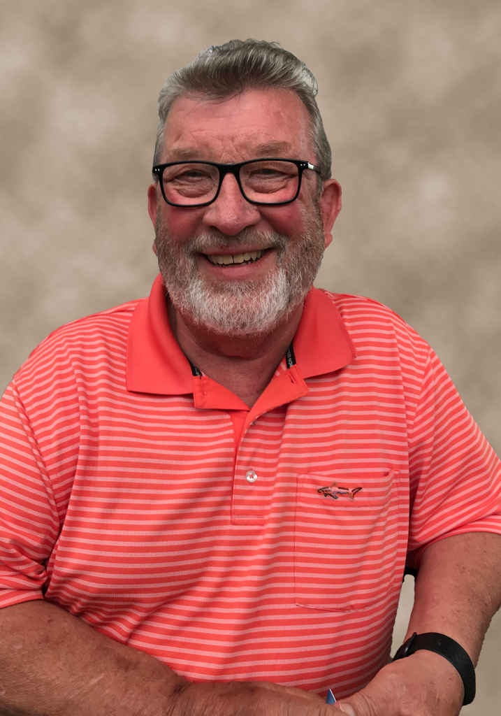 Man with glasses and a red striped shirt smiles.