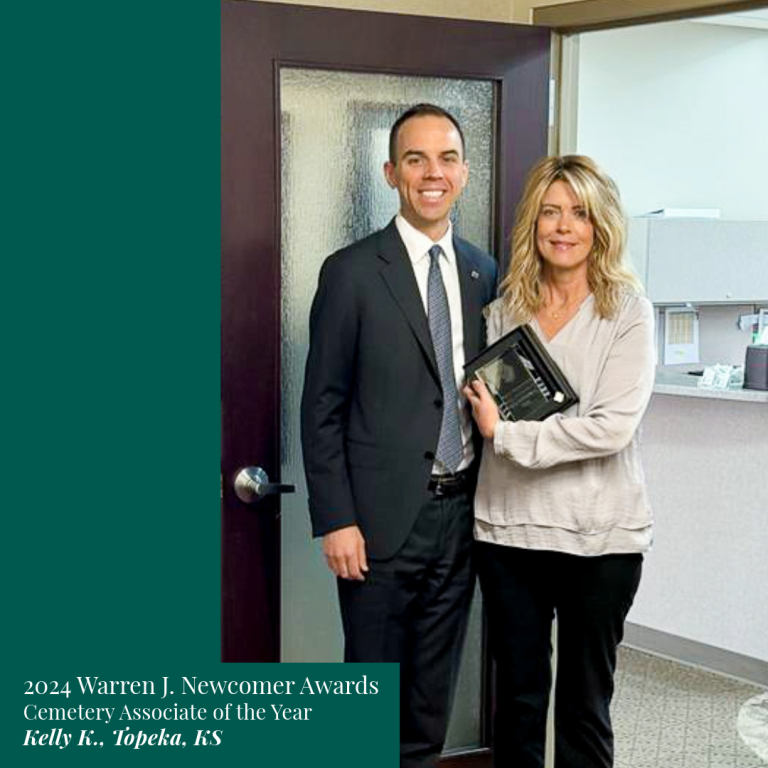 Two people, Kelly K. and a man, holding an award. They stand in an office doorway. Award text reads