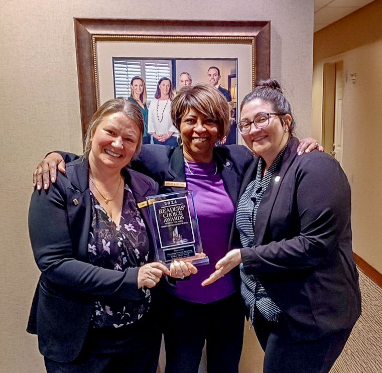 The front door of a house with a porch and plants in front of it.