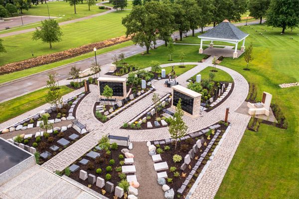 Aerial view of a memorial garden with pathways, landscaping, and a gazebo on a grassy landscape.