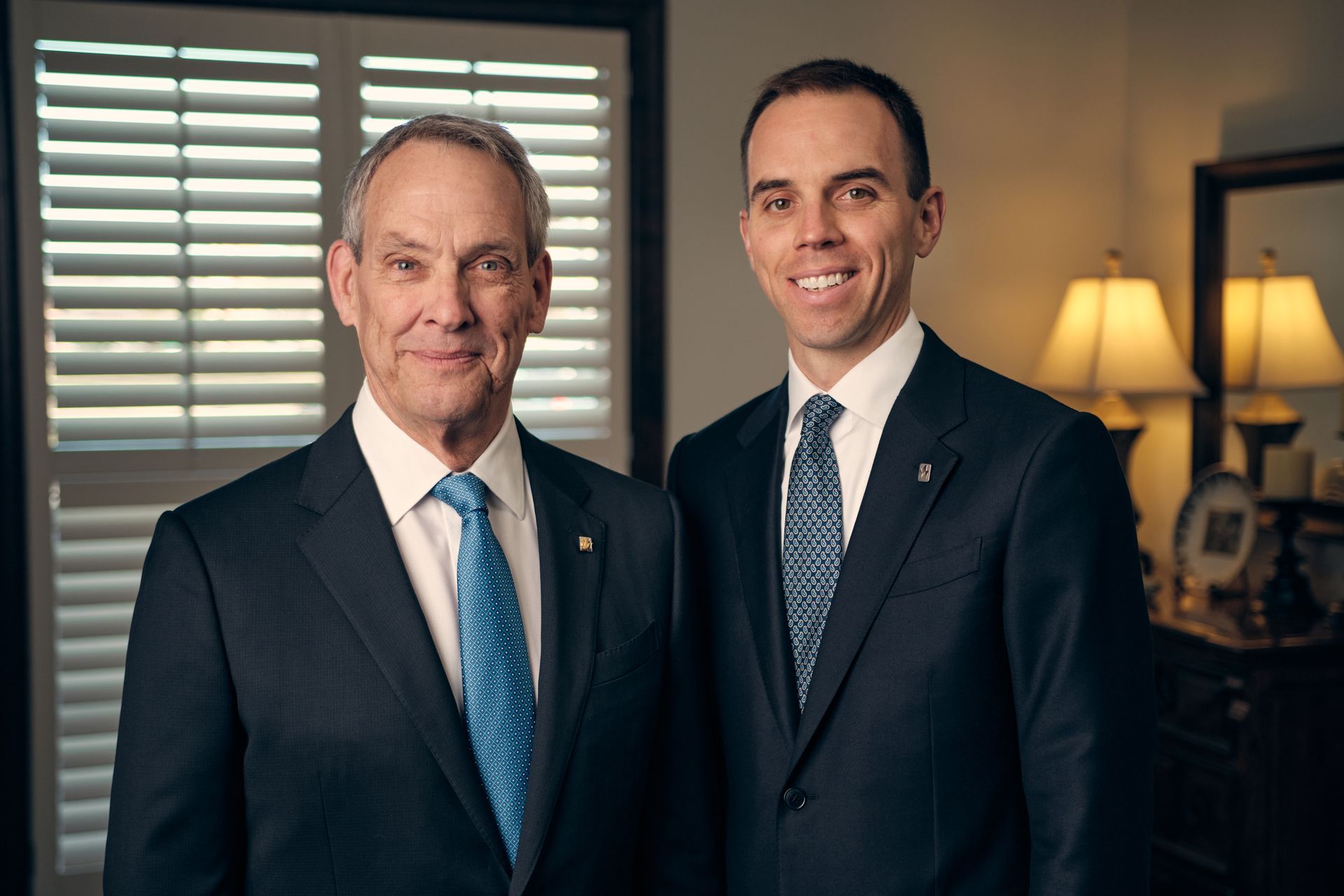 The front door of a house with a porch and plants in front of it.