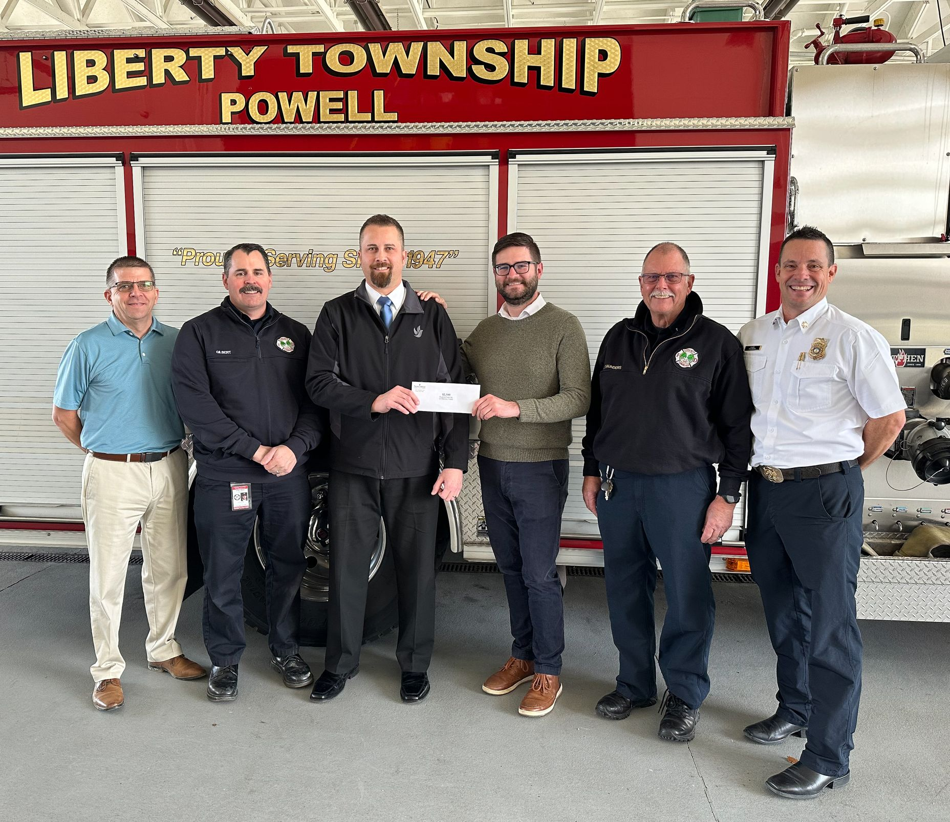 The front door of a house with a porch and plants in front of it.