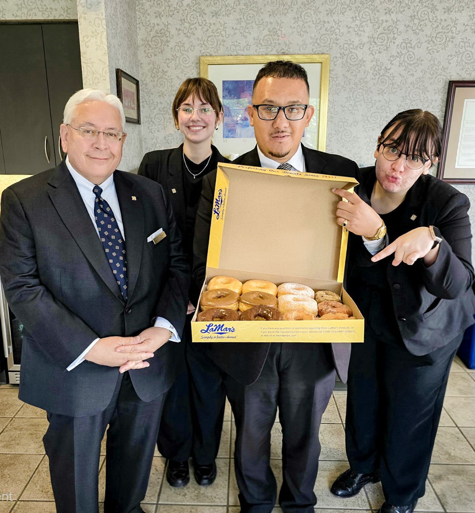 Lobby with couch, framed photos, and gold