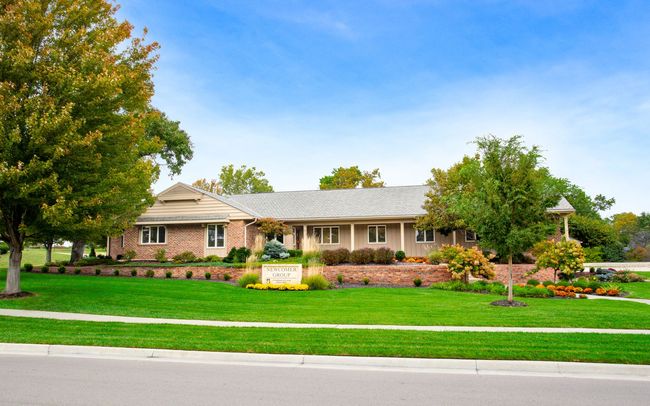 The front door of a house with a porch and plants in front of it.