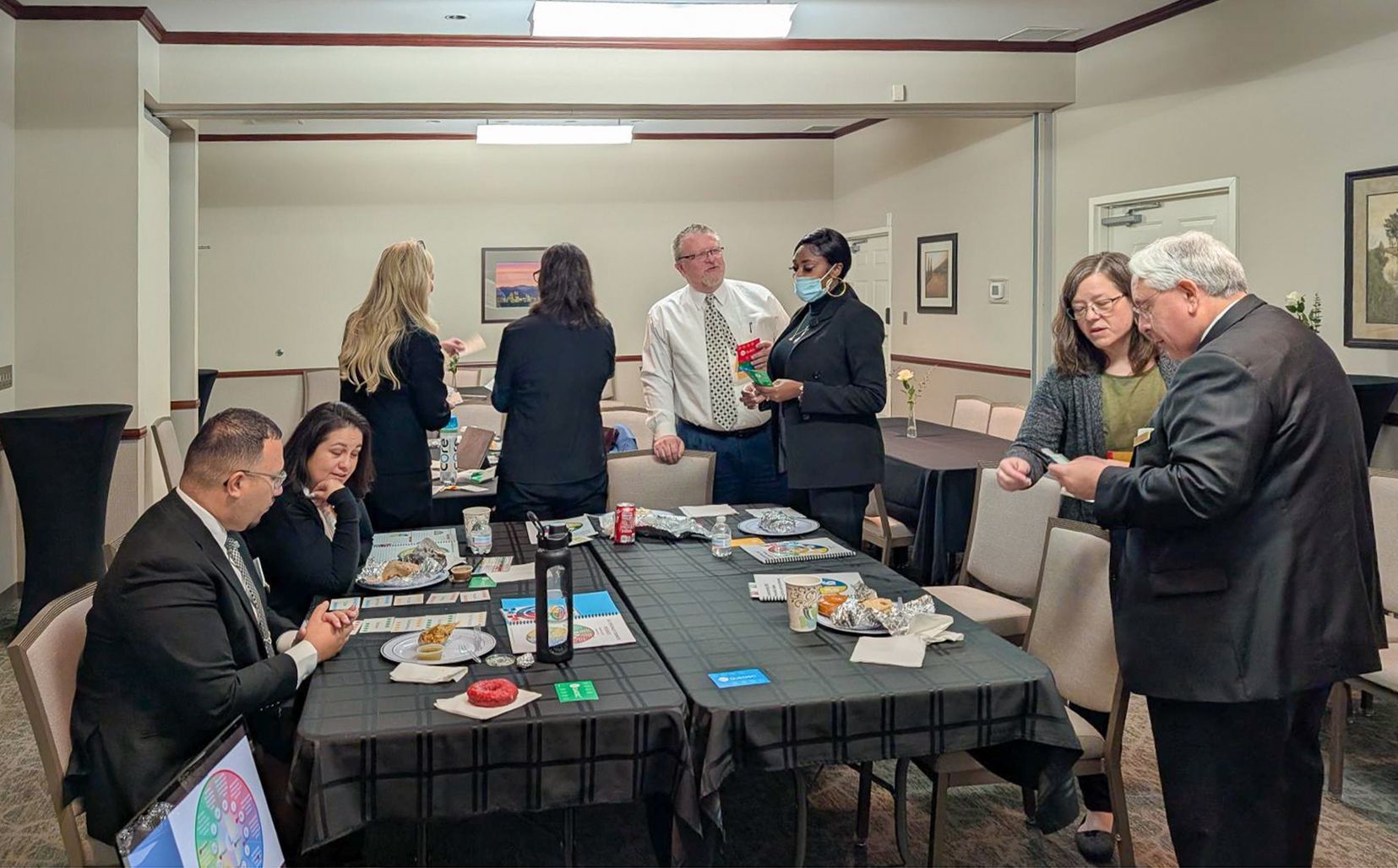 Memorial service: portrait of smiling man, flowers, and a candle on a wooden table, with rows of chairs in the background.