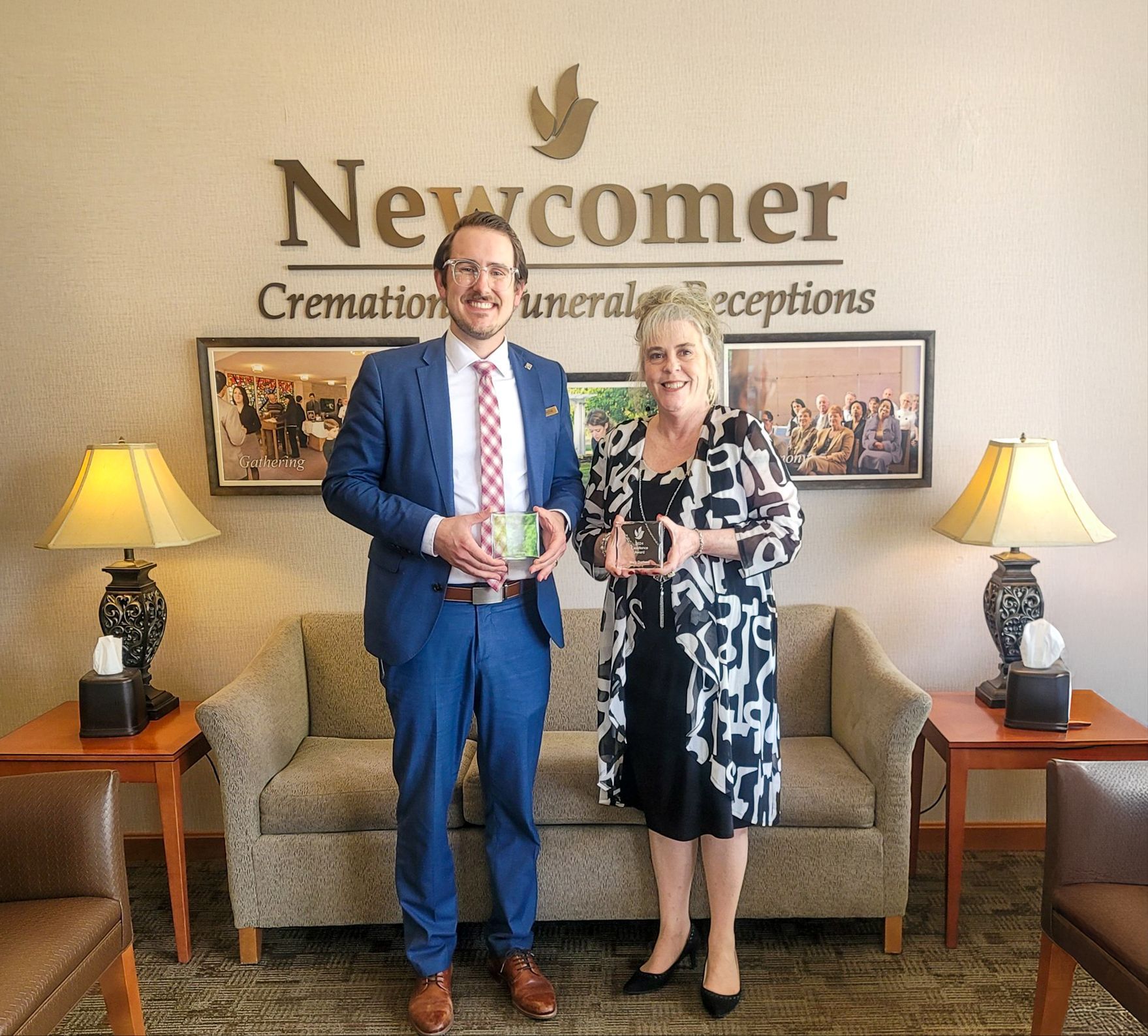 The front door of a house with a porch and plants in front of it.