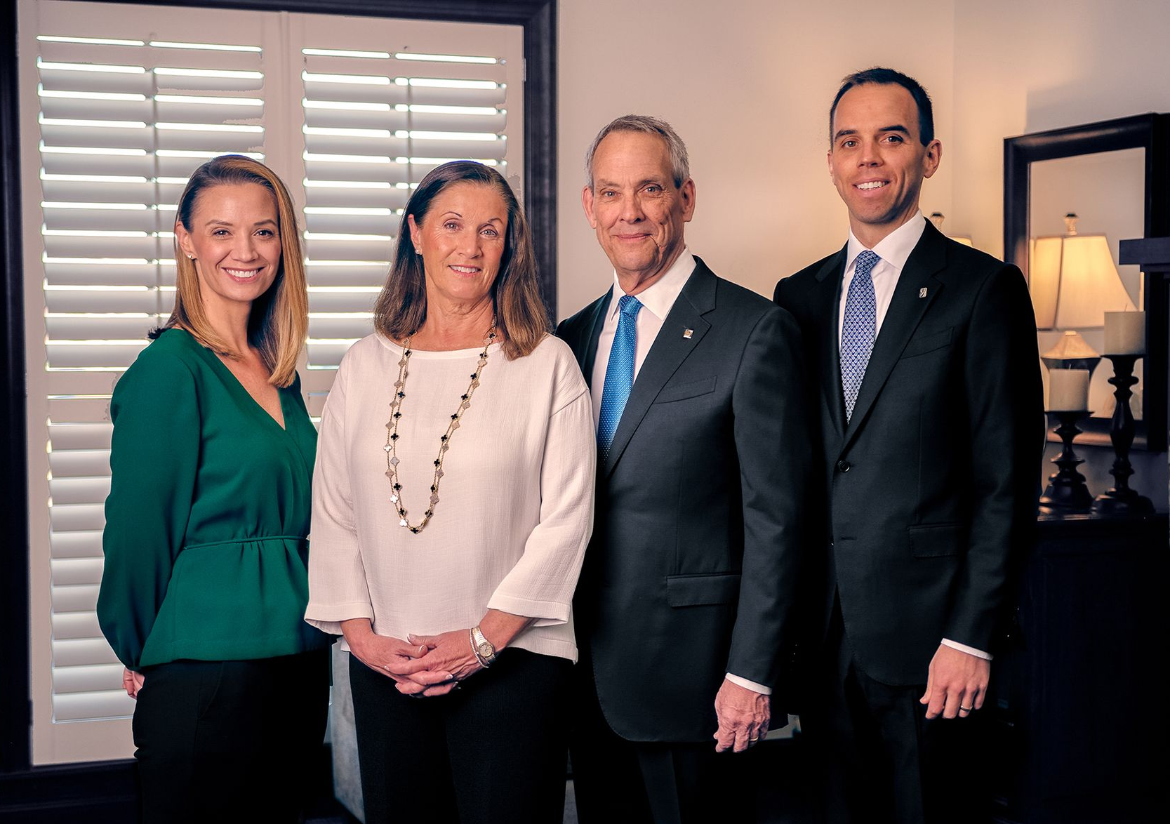 The front door of a house with a porch and plants in front of it.