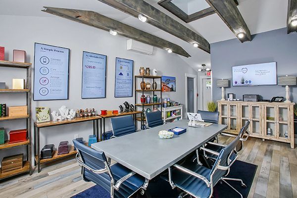 Modern office conference room with large table, blue chairs, and multiple presentation screens.