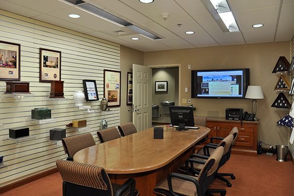 Conference room with a table, chairs, and display of urns and framed items.