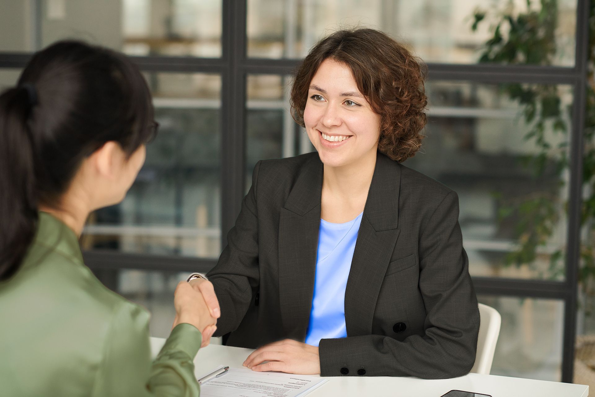 The front door of a house with a porch and plants in front of it.