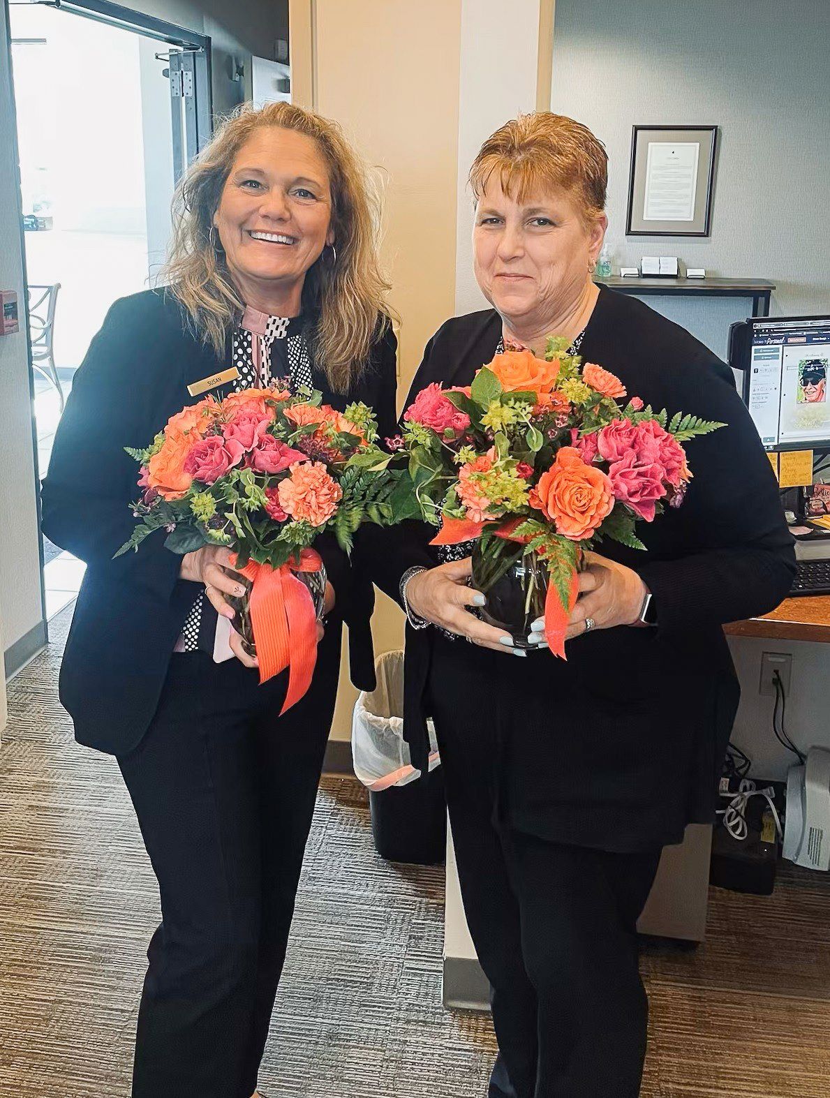 Group of people in office setting, holding popsicle treats. Decorated with paper sun and clouds.