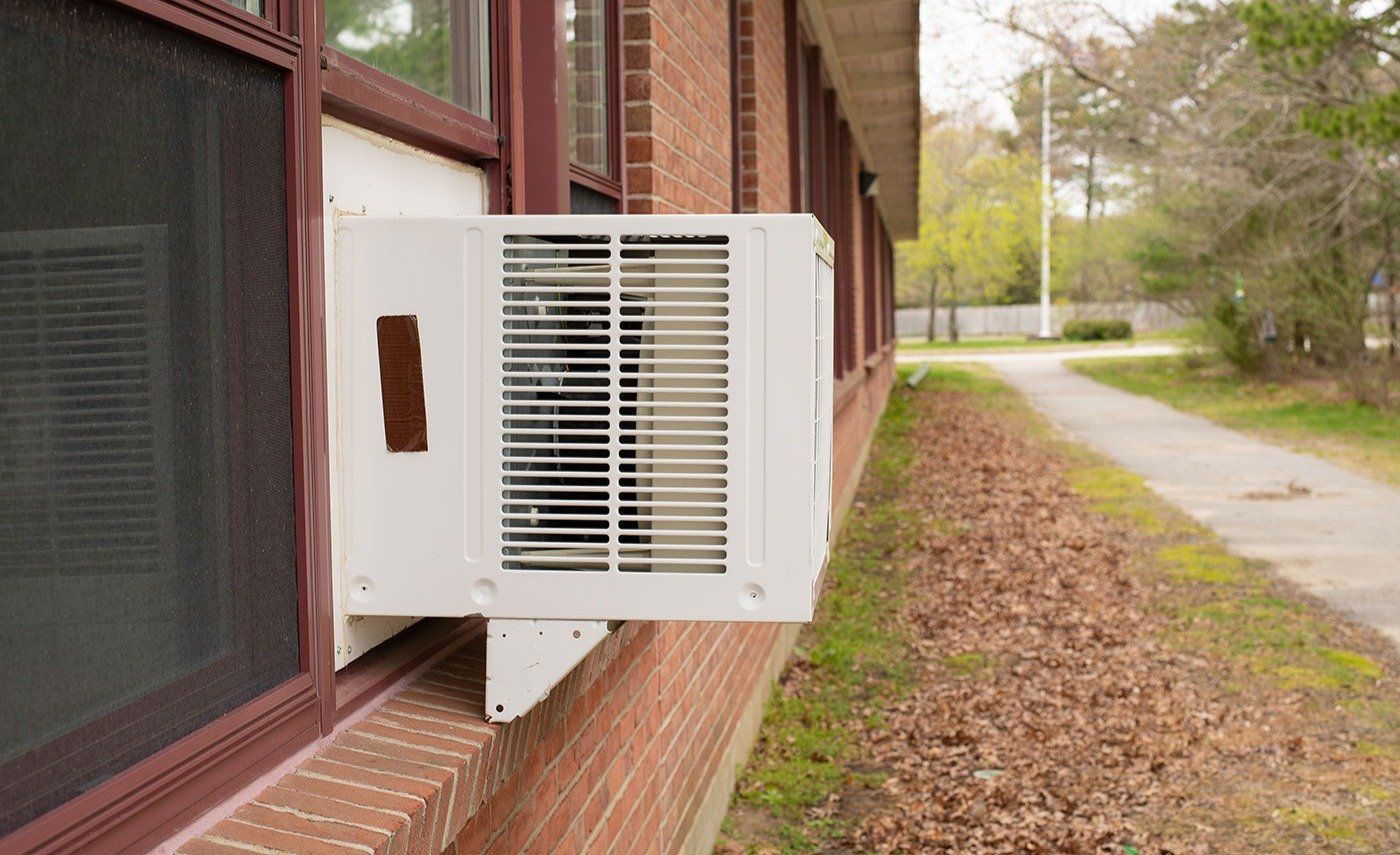 Window air conditioner unit in window in brick building