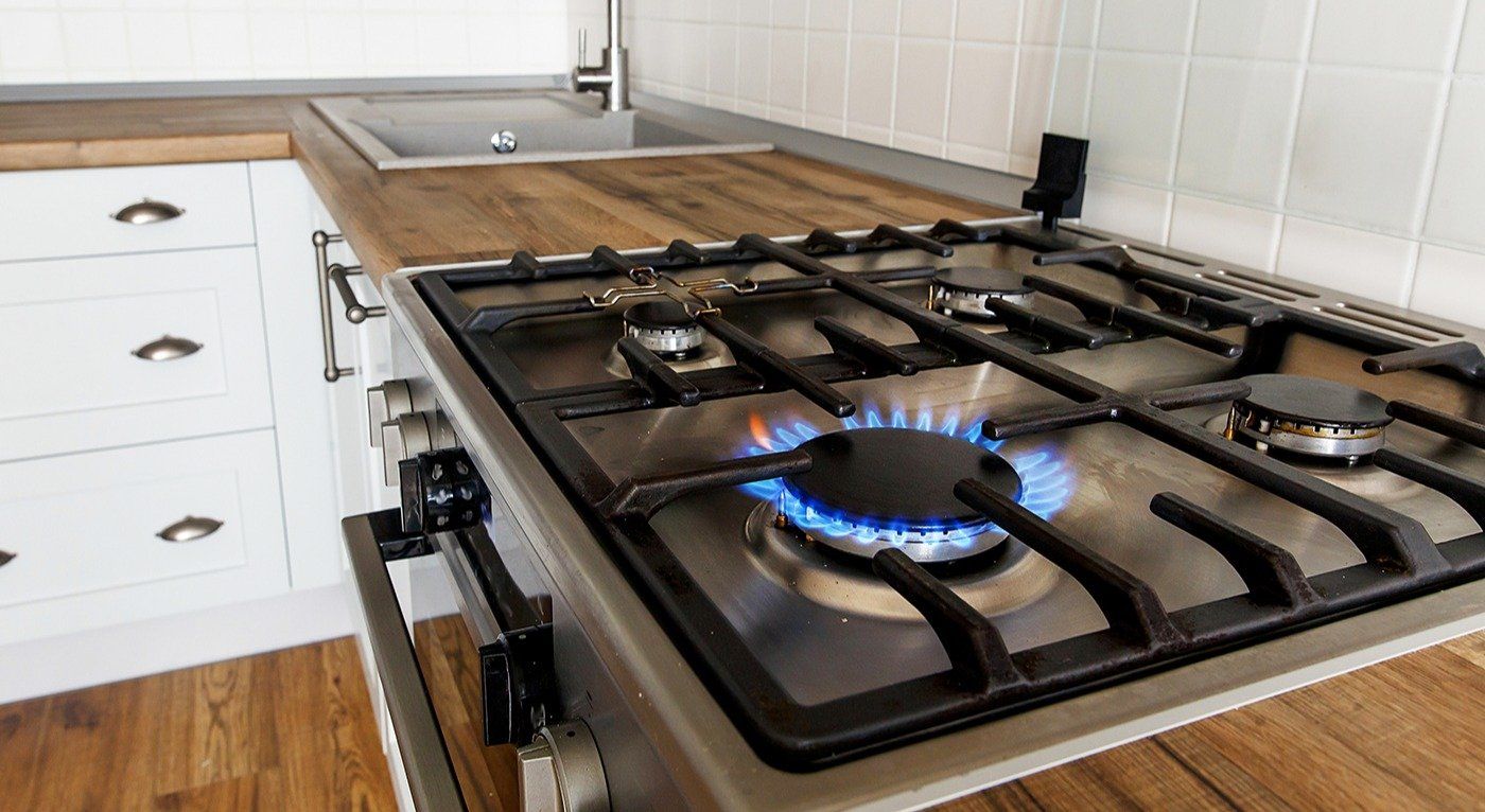 burning gas from kitchen stove on background of stylish kitchen interior