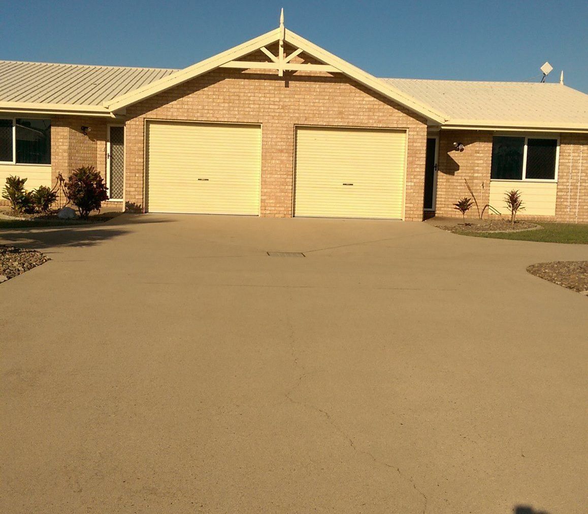 A Man is Using a High Pressure Washer to Clean a Brick Driveway — Blast H2O In Proserpine, QLD