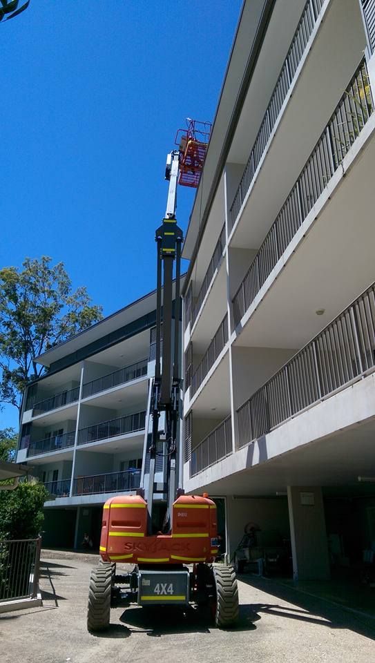 A Man is Cleaning a Garage Door With a High Pressure Washer — Blast H2O In Proserpine, QLD
