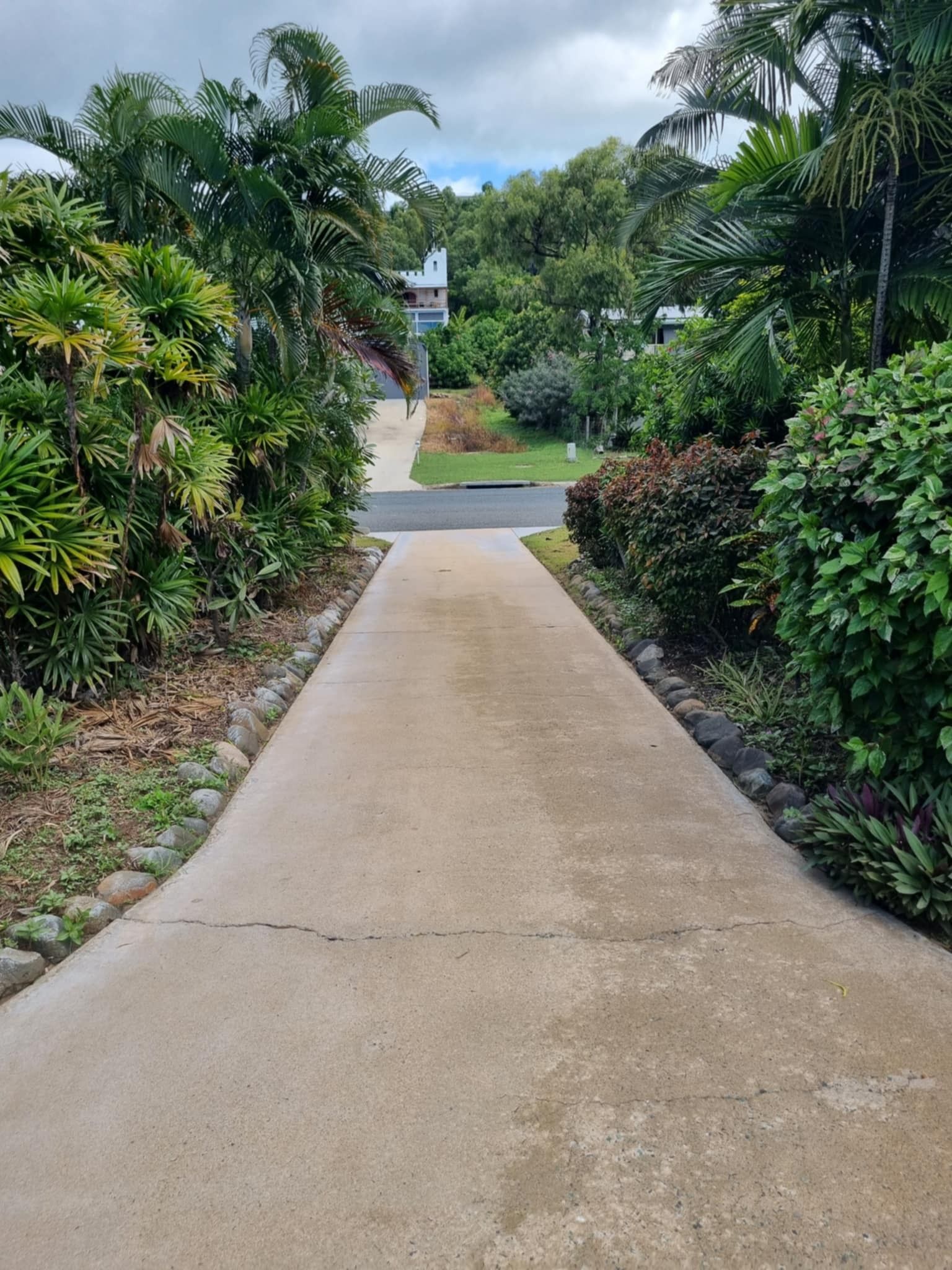 A Man is Cleaning the Sidewalk With a High Pressure Washer — Blast H2O In Proserpine, QLD