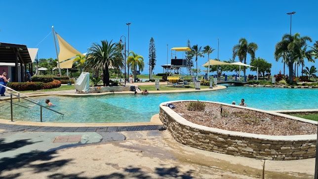 A Large Swimming Pool Surrounded by Palm Trees on a Sunny Day — Blast H2O In Airlie Beach, QLD