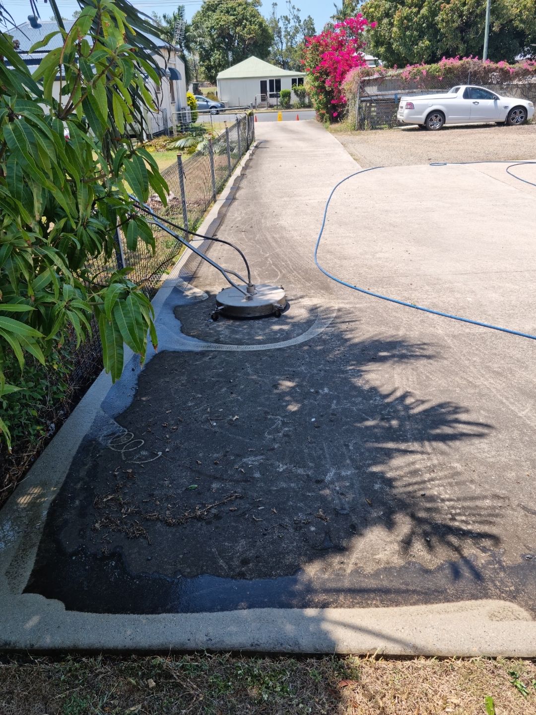A Man is Using a High Pressure Washer to Clean a Concrete Floor — Blast H2O In Proserpine, QLD