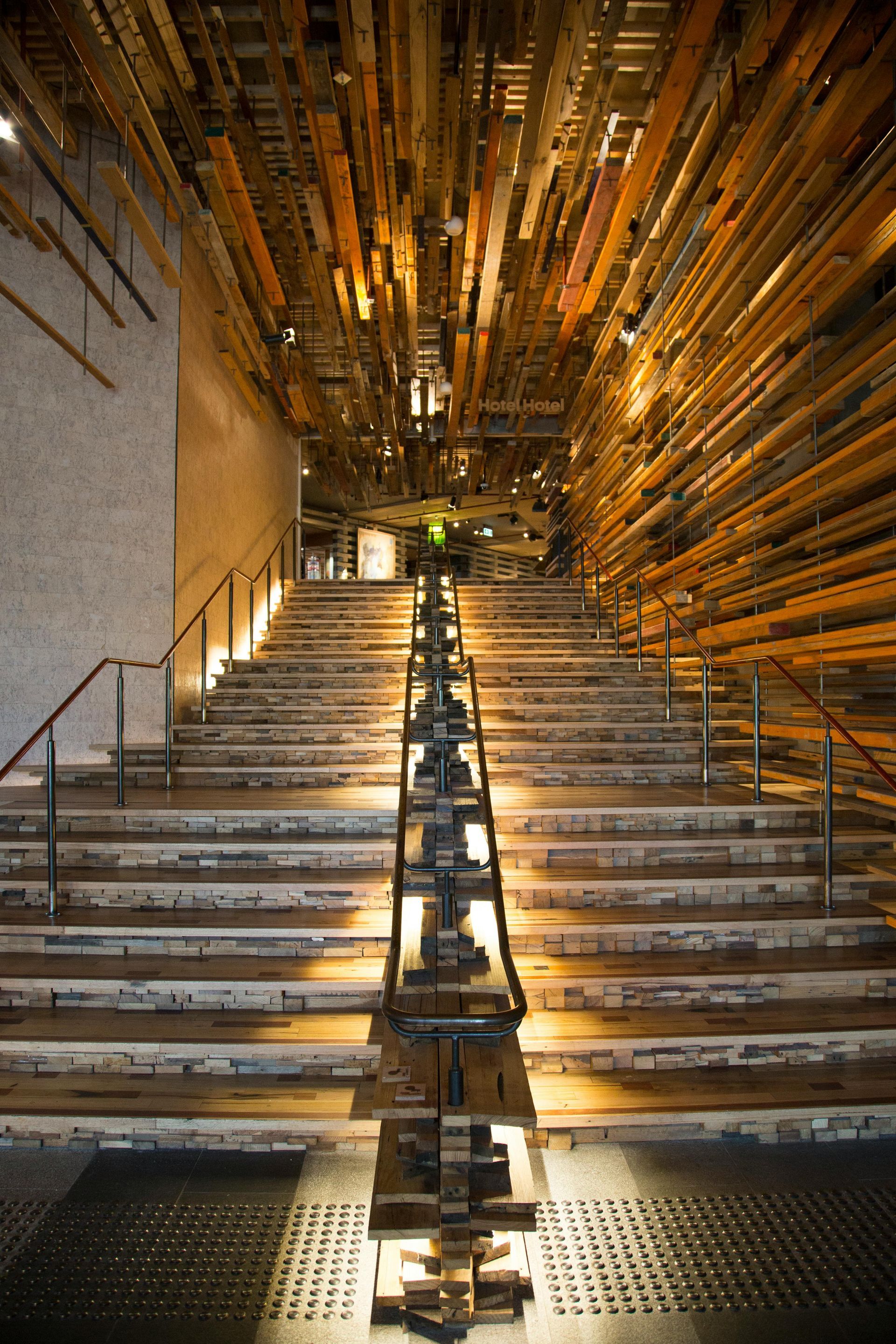 A row of wooden stairs leading up to the ceiling of a building.
