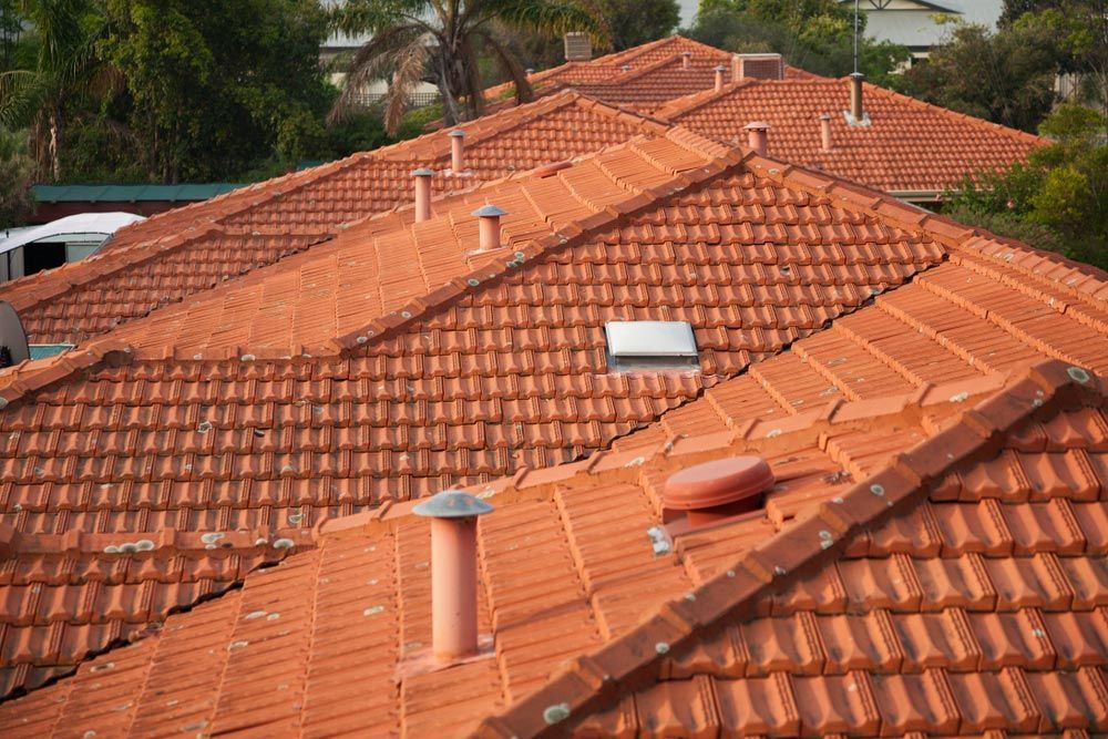 A Row of Red Tile Roofs With Chimneys on Them — East Coast Roof Tiling Services in Buderim, QLD
