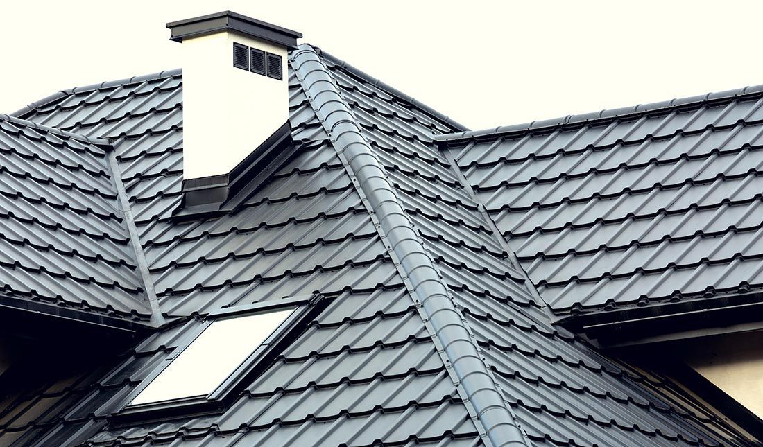 A Roof With a Chimney and Two Skylights on It — East Coast Roof Tiling Services in Kuluin, QLD